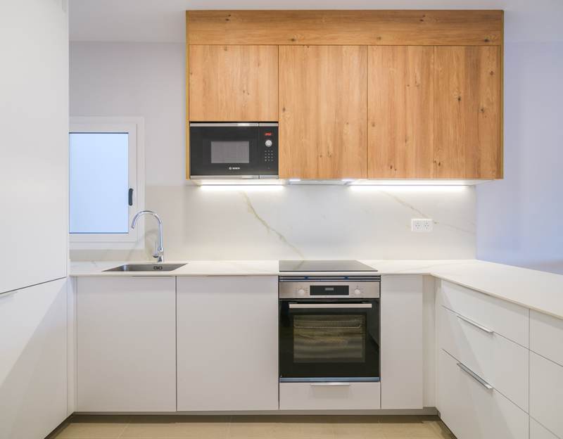 Cocina blanca con frentes de madera